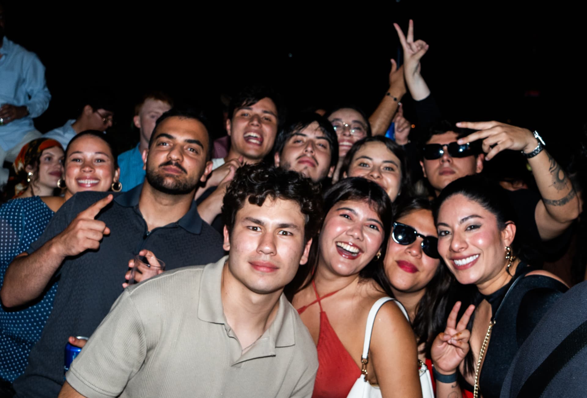 Packed crowd smiling and throwing peace signs on the floor at a Parkway night