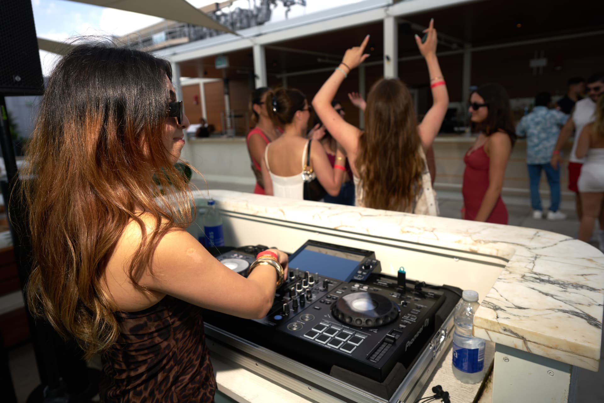Hands in the air on the rooftop as the DJ mixes through the daytime set