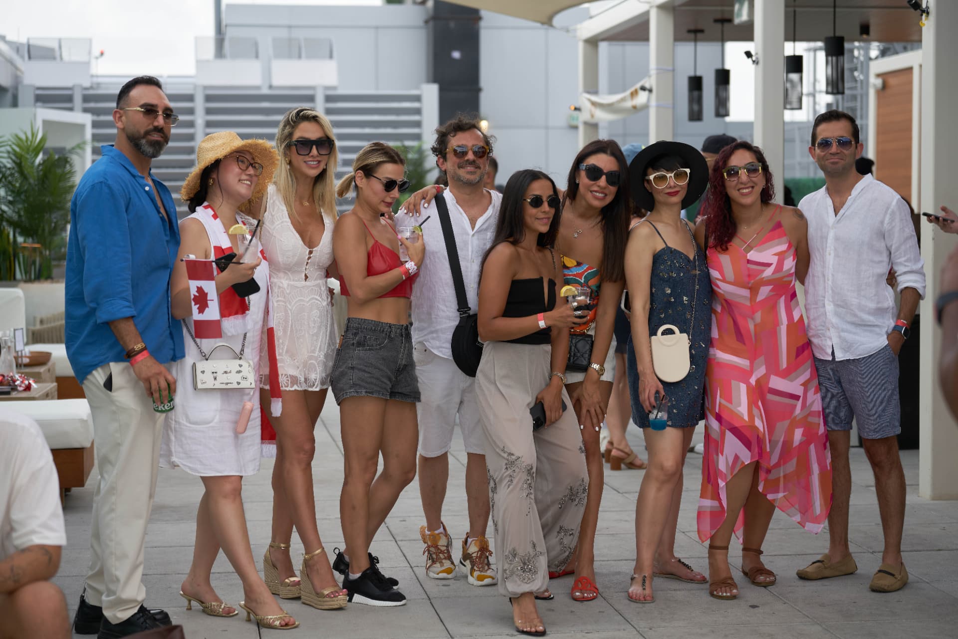 Group portrait of guests posing together on the daytime rooftop terrace
